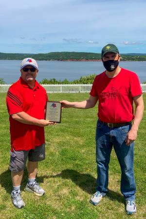 Clayton Harvey being presented with the Minor Hockey Association Volunteer of the Year Awards from Association President René Haché